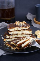 A stack of cut pancakes with a banana.