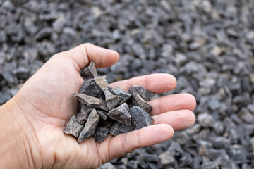 Brita held by the hand of a white man in the middle of a quarry. Material widely used in civil construction for mass formation together with sand and cement in the junction of bricks and foundation.