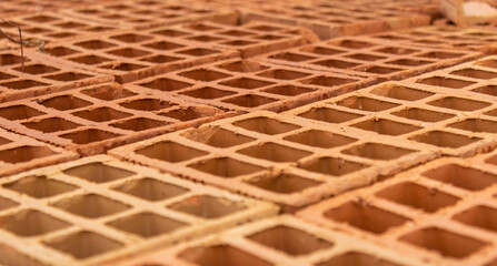 Set of orange building bricks lined with square holes and different shades. They form an interesting texture. Used in the construction of houses and buildings.