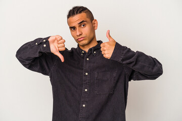 Young venezuelan man isolated on white background showing thumbs up and thumbs down, difficult...
