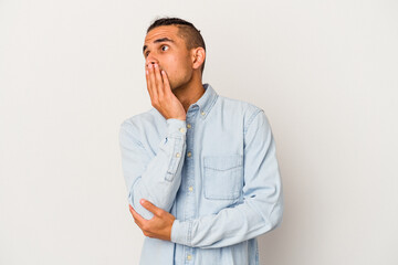 Young venezuelan man isolated on white background yawning showing a tired gesture covering mouth with hand.