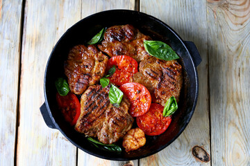 Appetizing juicy grilled steak with grilled vegetables in a pan. Close-up.