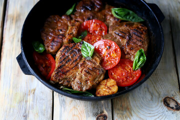 Appetizing juicy grilled steak with grilled vegetables in a pan. Close-up.