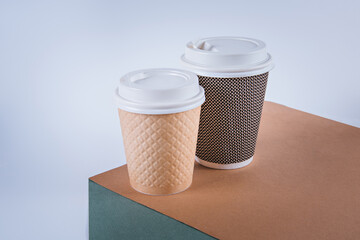 Two craft paper disposable coffee cups. Banner with a white background.