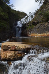 Fototapeta na wymiar Paisagem de rio com cachoeira ao fundo na vertical