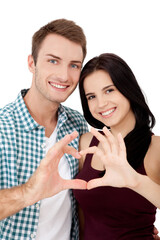 Beautiful young lovers are joining and smiling, making a heart frame from their hands