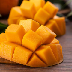 Mango. Fresh mango fruit with leaves over dark wooden table background.