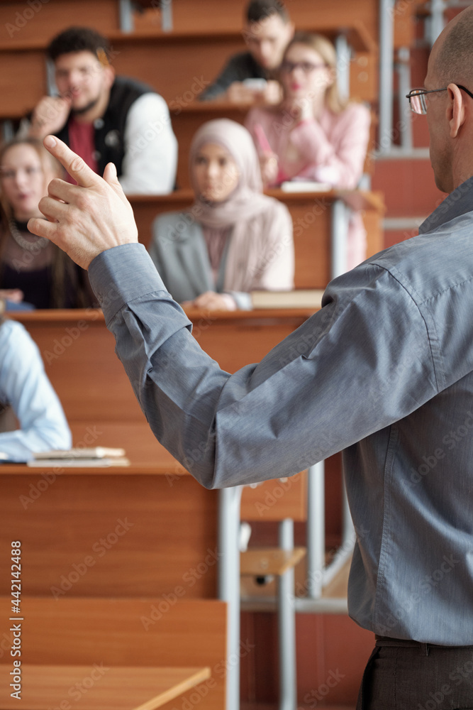 Poster teacher gesturing in front of group of students during explanation