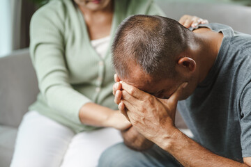 Female friend or family sitting and hold hands during cheer up to mental depress man, Psychologist provides mental aid to patient. PTSD Mental health concept.