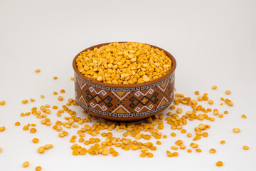 Close-up of Organic Bengal Gram (Cicer arietinum) or split yellow chana dal inside a  bowl. White isolated background.