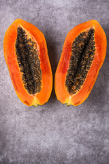 fresh sweet papaya or papaw, vibrant color fruit slices isolated on a textured background, top down view