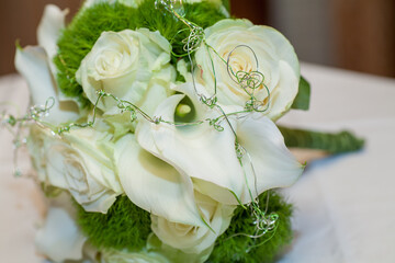 Close view on calla flowers with wedding rings in warm colors. High quality photo