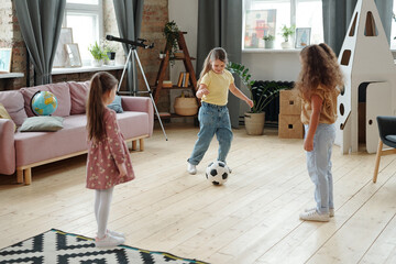 Adorable kids playing football on the floor of living-room
