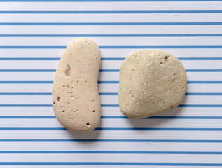 two stones on striped paper background