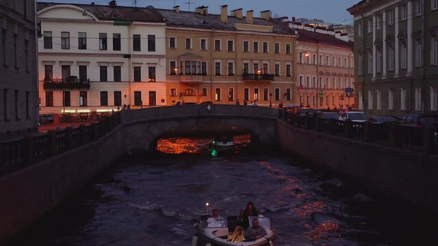 4k video. Tourist ships sail through the canals at night. Saint Petersburg, Russia - 28 June 2021