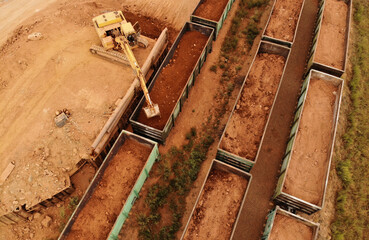 large excavator loads rock with iron or bauxite mining