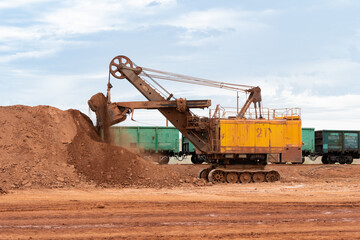 Fototapeta na wymiar large excavator loads rock with iron or bauxite mining