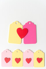 pastel colored wood chalkboard tags with hand painted red hearts, loosely arranged in a retro style - photographed on a white background in a top-down style