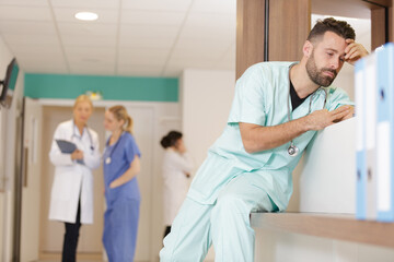male doctor leaning on reception desk