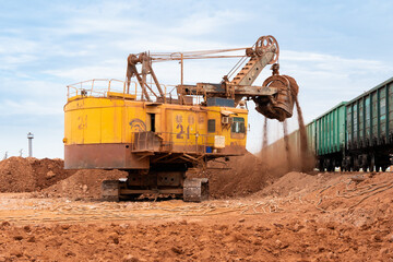 large excavator loads rock with iron or bauxite mining