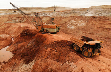 large excavator loads rock with iron or bauxite mining