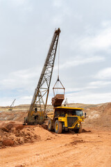 large excavator loads rock with iron or bauxite mining