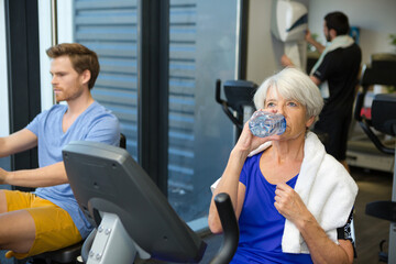 Fototapeta na wymiar senior lady drinking water at the gym