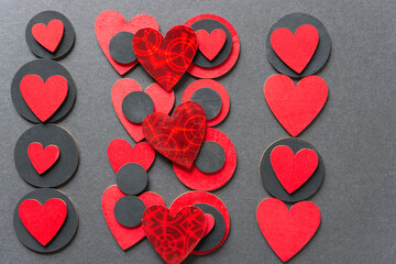 black circles and hand painted old school hearts loosely arranged on a dark gray paper background