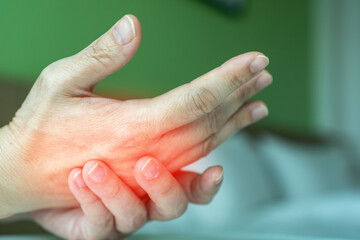 Overuse hand problems. Woman’s hand with red spot on fingers as suffer from Carpal tunnel...