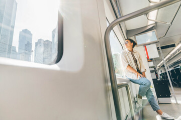 Woman traveling on the train looking to the city through the window.