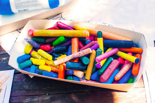 A box with colored wax crayons on the table.