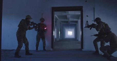 Masked Team of Armed Modern Warfare Soldiers Team Move in Tactical Formation in a Dark Urban Battlefield Indoors.Soldiers Squad with Rifles and Flashlights in action.