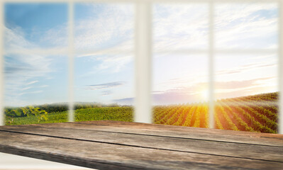 photomontage of wooden table with white window and view of green vineyard landscape