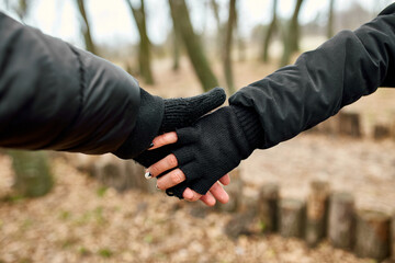 Modern young couple holding hands while standing in the woods outdoor travel concept