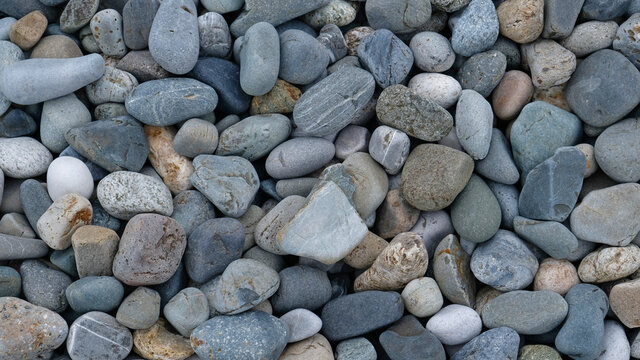 Sea or river gray pebbles. Natural texture of beach pebbles. Weathering and erosion of rocks. Drainage systems from small pebbles. Garden drainage for plants and trees. Blue stones for roads.