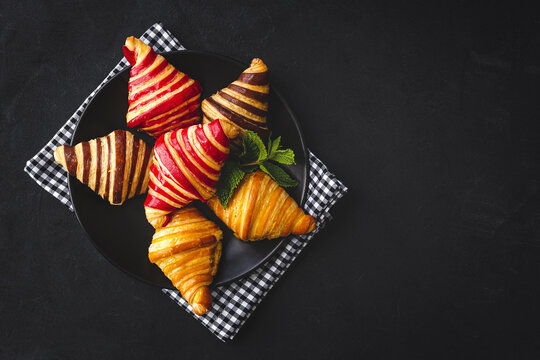 Appetizing croissants in basket on table