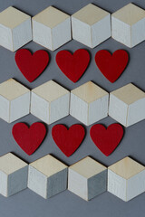 low-key photo with trompe l'oeil cubes and red hearts on gray
