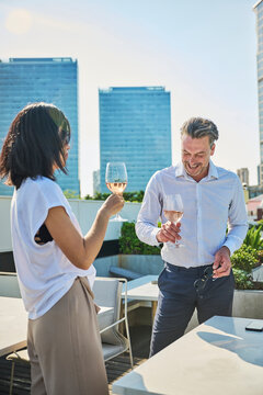 Designer and workmate having a cup of white wine after work