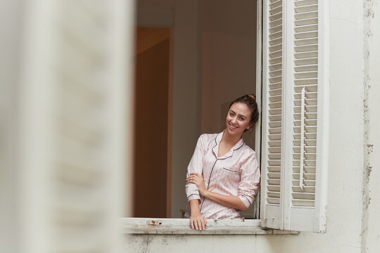 Calm woman standing on window