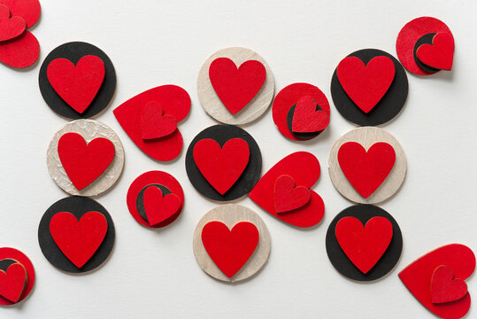 hand painted red and black shapes (hearts and circles) - loosely arranged on a light background - photographed from above under ambient light conditions