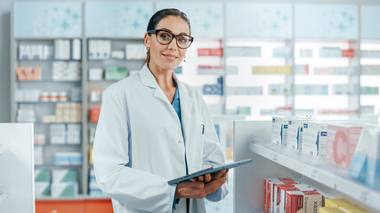 Pharmacy: Portrait of Professional Beautiful Caucasian Female Pharmacist Uses Digital Tablet...