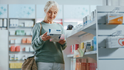 Pharmacy Drugstore: Portrait of a Beautiful Senior Woman Choosing to Buy Medicine, Drugs, Vitamins. Apothecary Full of Health Care Products, Supplement Bottles, Beauty Packages with Modern Design