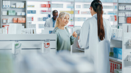 Pharmacy: Professional Caucasian Pharmacist Helping Beautiful Senior Female Customer with Medicine...