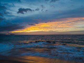Colored sky over the sea. Waves on the sand. Amazing sunset at Maluaka Beach, Maui Island. Beautiful nature of Hawaii