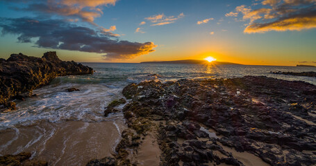 Waves and rocks. Colored clouds over the sea. Amazing sunset. Beautiful nature of Hawaii. Maui island
