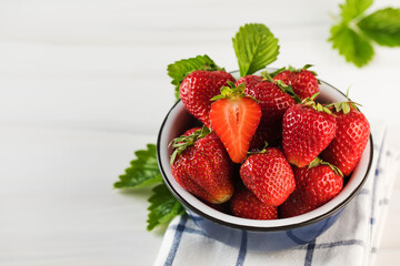 Fresh ripe strawberries in a bowl on a white background. Eco-products.