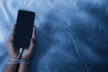Hand holding smartphone; addiction concept