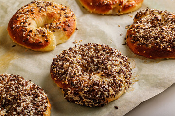 Fresh and crispy New York bagels with sesame and flax seeds. The best homemade New York-Style Bagel Recipe. Crusty sesame tasty buns. Homemade baking. Hot bagels on baking paper. Cook at home