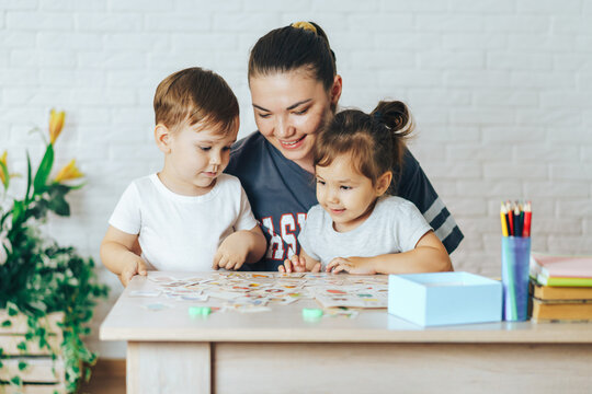 Mother playing with her children at home in cards, Leisure activity at home