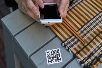 Crop man scanning QR code of restaurant menu